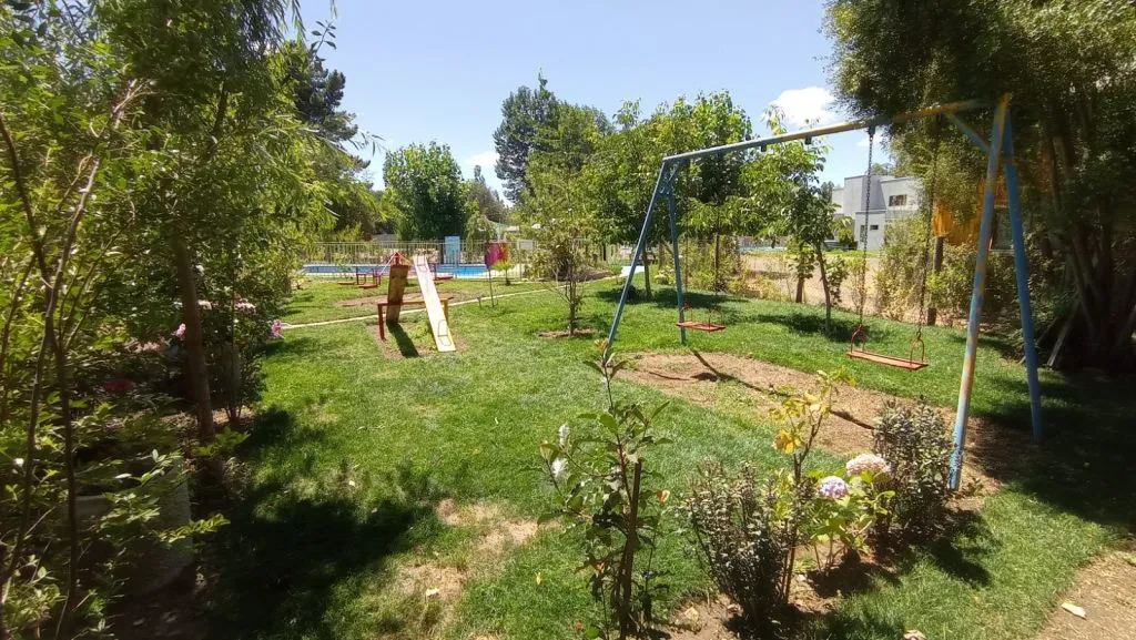 Juegos infantiles con tobogán y columpios en jardín verde de Los Nogales 2