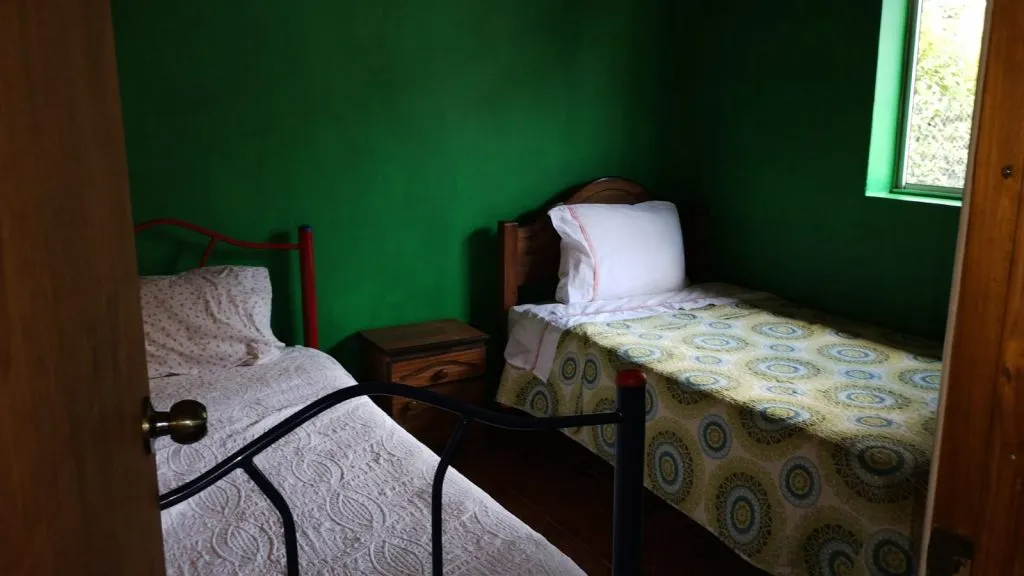 Living-comedor con sofá, TV, estufa a combustión lenta y mesa en cabaña Los Nogales 2